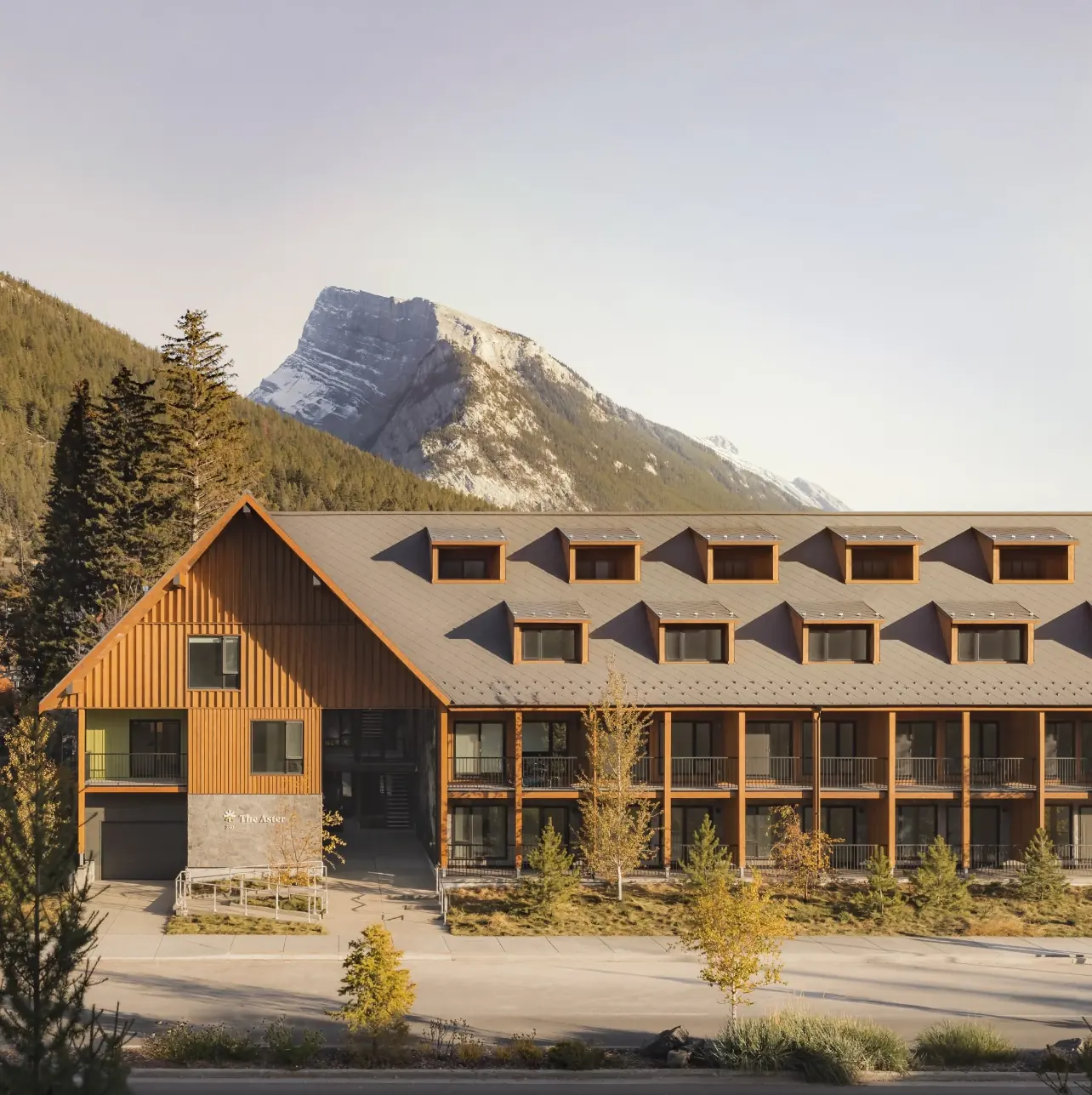The Aster timber-clad housing façade beneath the mountains in Banff